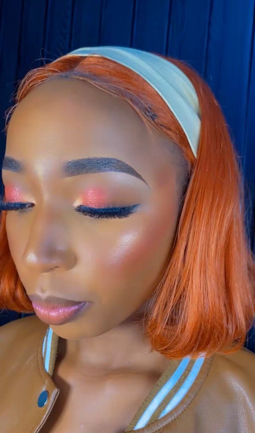 Beauty close-up, coral orange wig with cream headband, sunset eyeshadow blend with lifted lashes, eyes closed against deep navy